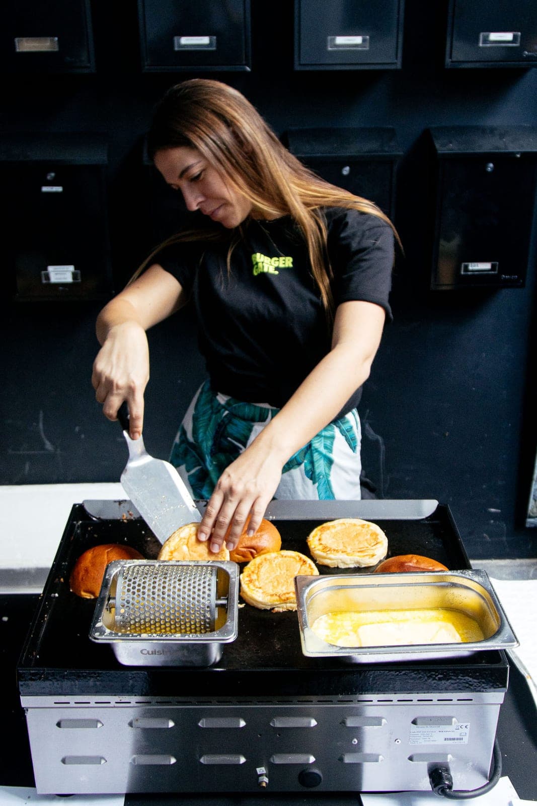 Een crewlid toast broodjes op de bakplaat