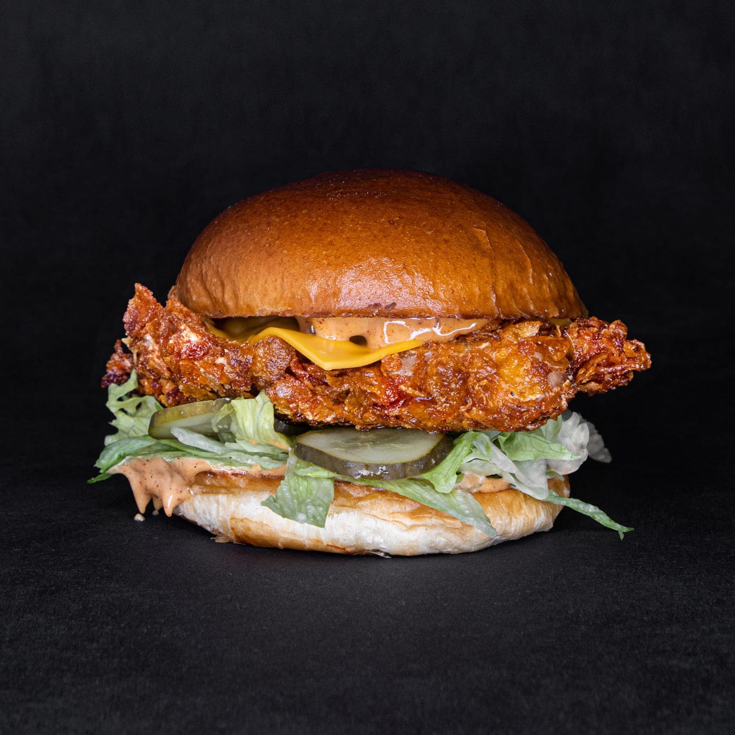 De chicken burger op een zwarte achtergrond