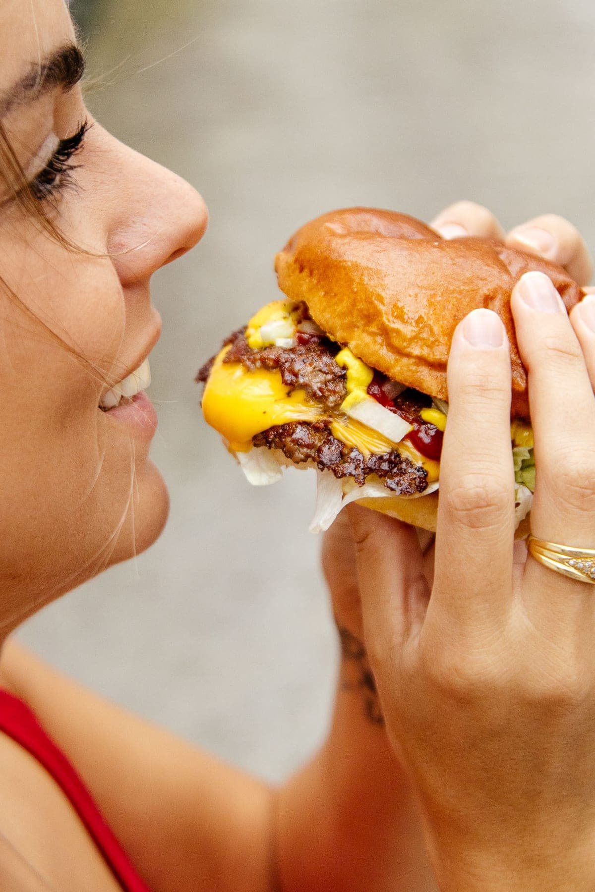 Een gast bijt in een smash burger met gesmolten kaas