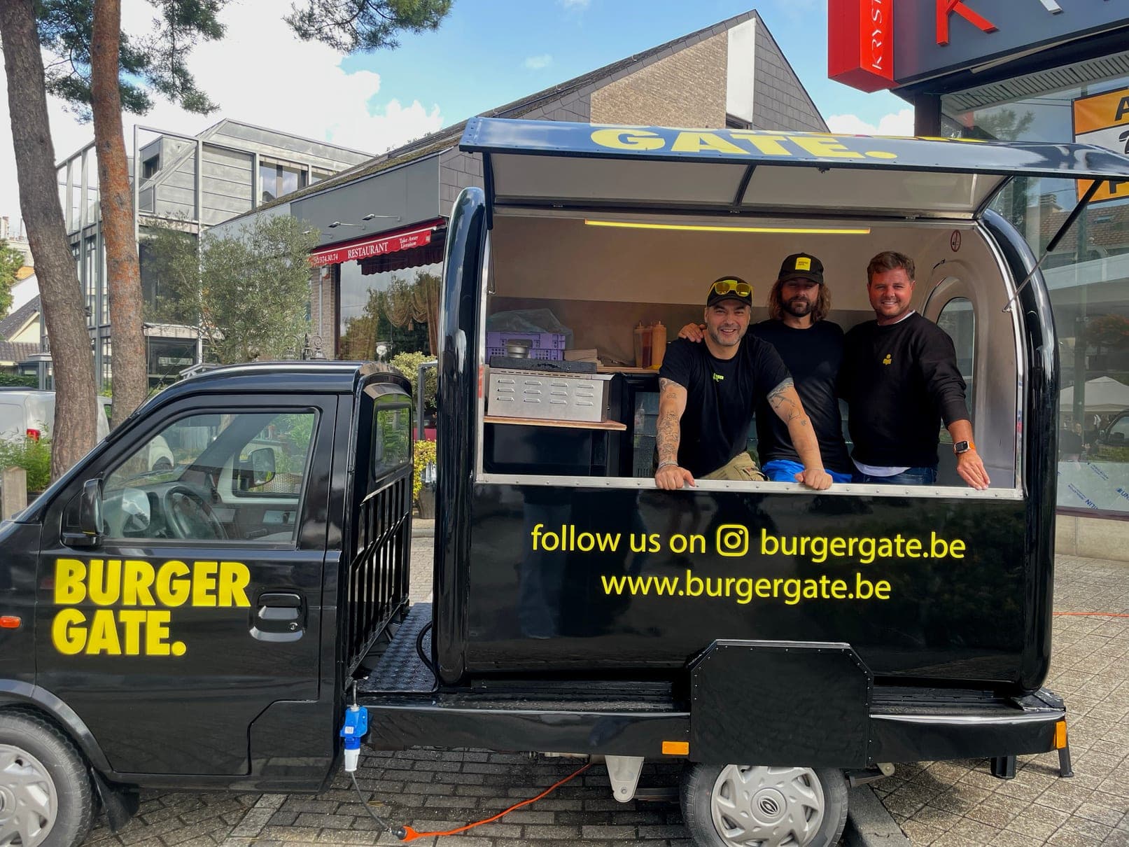 De zwarte Burgergate-truck met de crew aan het luik